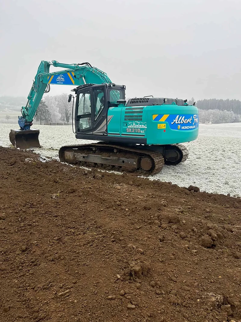 Bagger von Alb. Frei beim Aushub auf einem verschneiten Feld