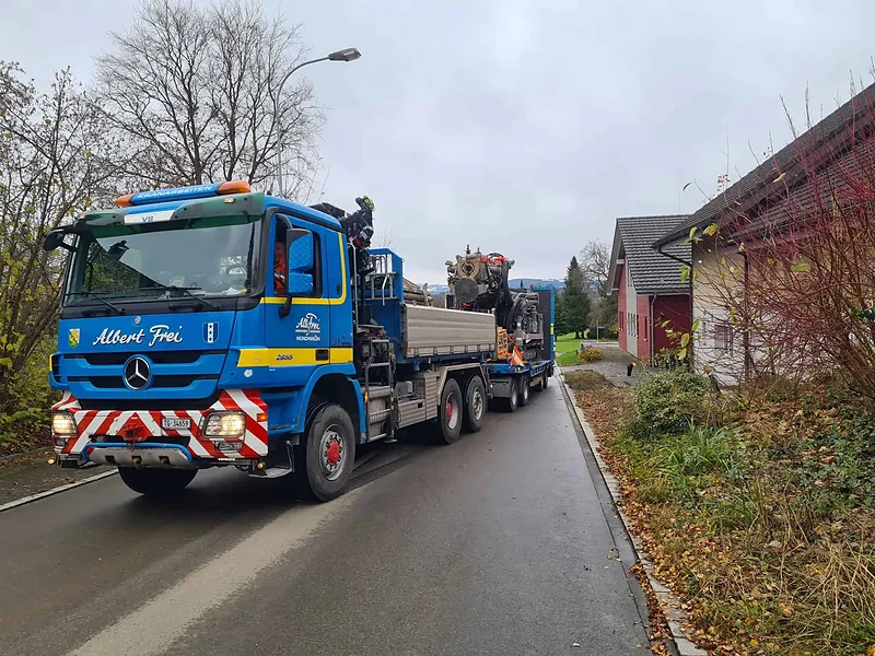 Kranlastwagen von Alb. Frei mit Anhänger in einer Quartierstrasse