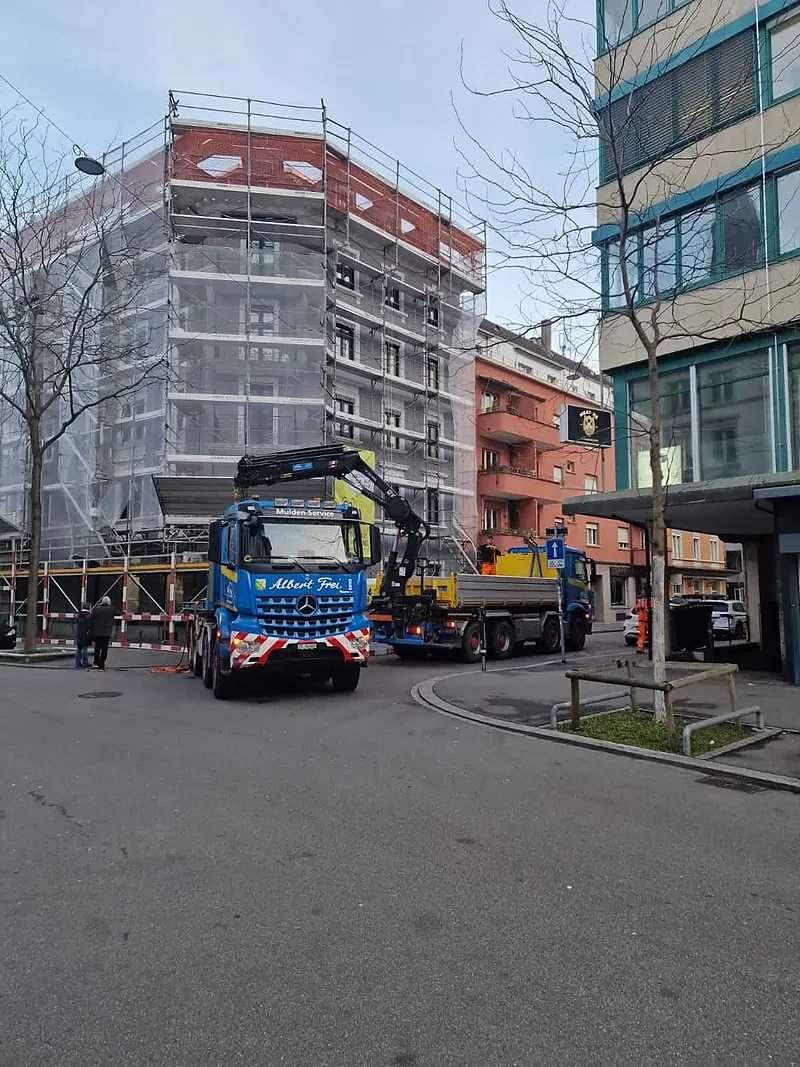 Lastwagen von Alb. Frei an einer Baustelle mit eingerüstetem Neubau