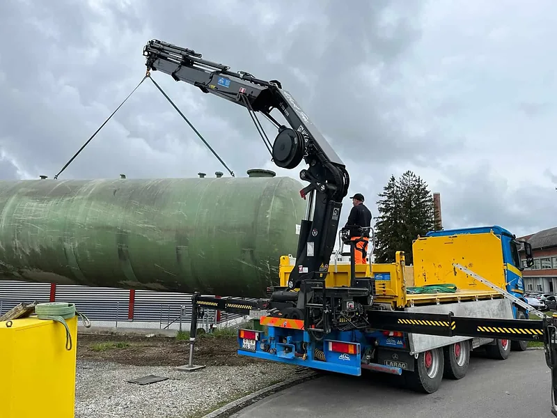 Kranwagen von Alb. Frei hebt einen Tank vom Anhänger