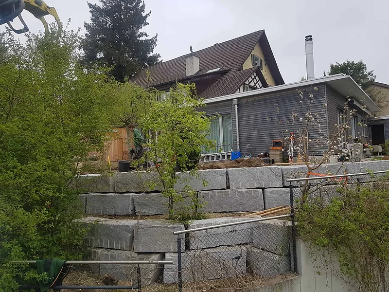 Blocksteinmauer als Hangsicherung an einem Wohnhaus