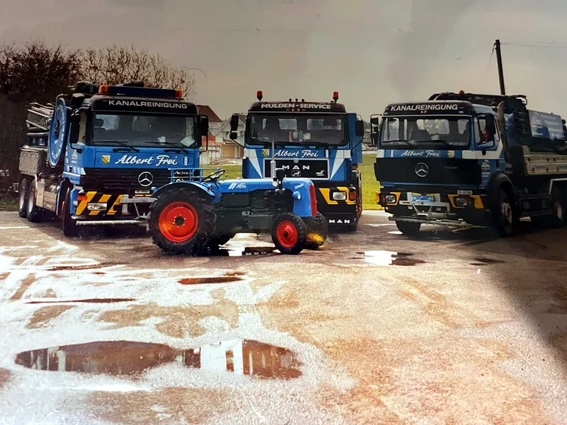 Zwei Kanalreinigungsfahrzeuge, ein Muldenwagen und ein Traktor von Albert Frei, historische Aufnahme