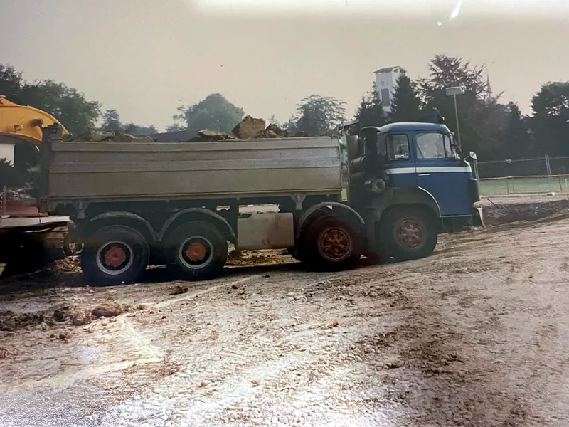 Saurer-Dreiachskipper mit Aushub auf einer Baustelle, historische Aufnahme