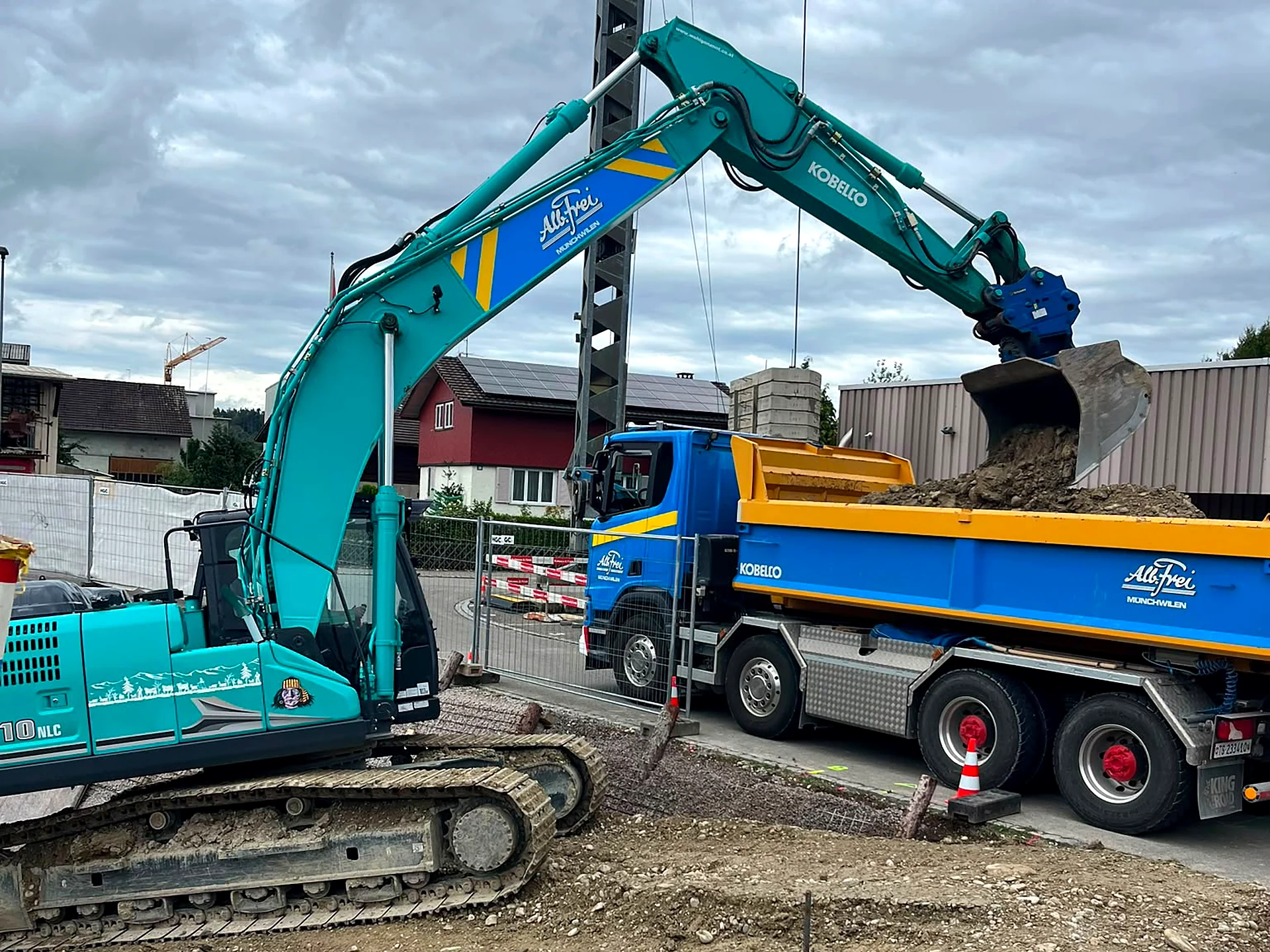 Kobelco-Bagger von Alb. Frei belädt einen Kipper mit Aushub auf einer Baustelle