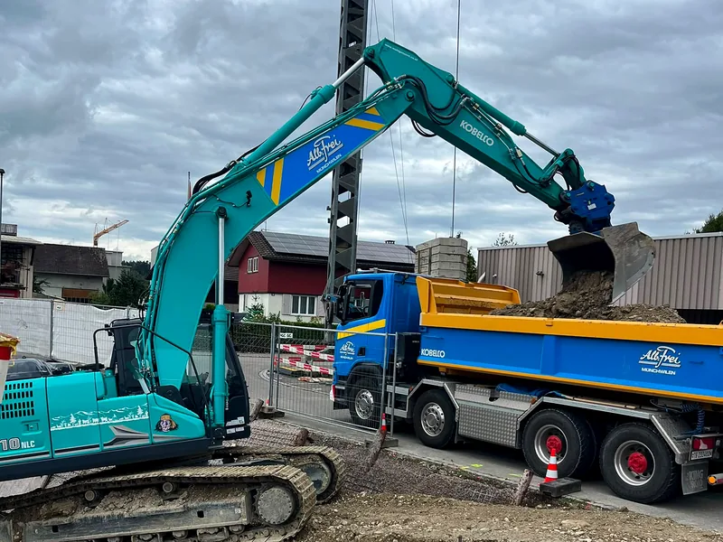 Kobelco-Bagger lädt Aushub auf einen Kipper von Alb. Frei