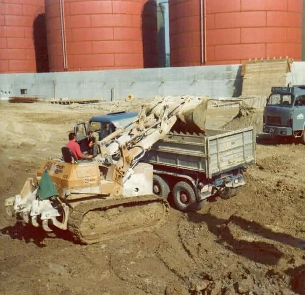 Raupenbagger belädt einen Lastwagen der Alb. Frei Transporte AG auf einer Grossbaustelle
