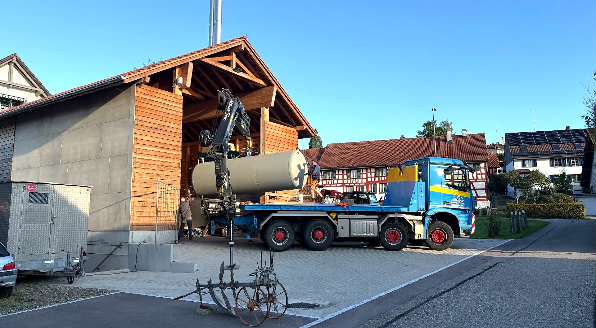 Lastwagen von Alb. Frei hebt mit dem Ladekran einen Tank in eine Holzscheune